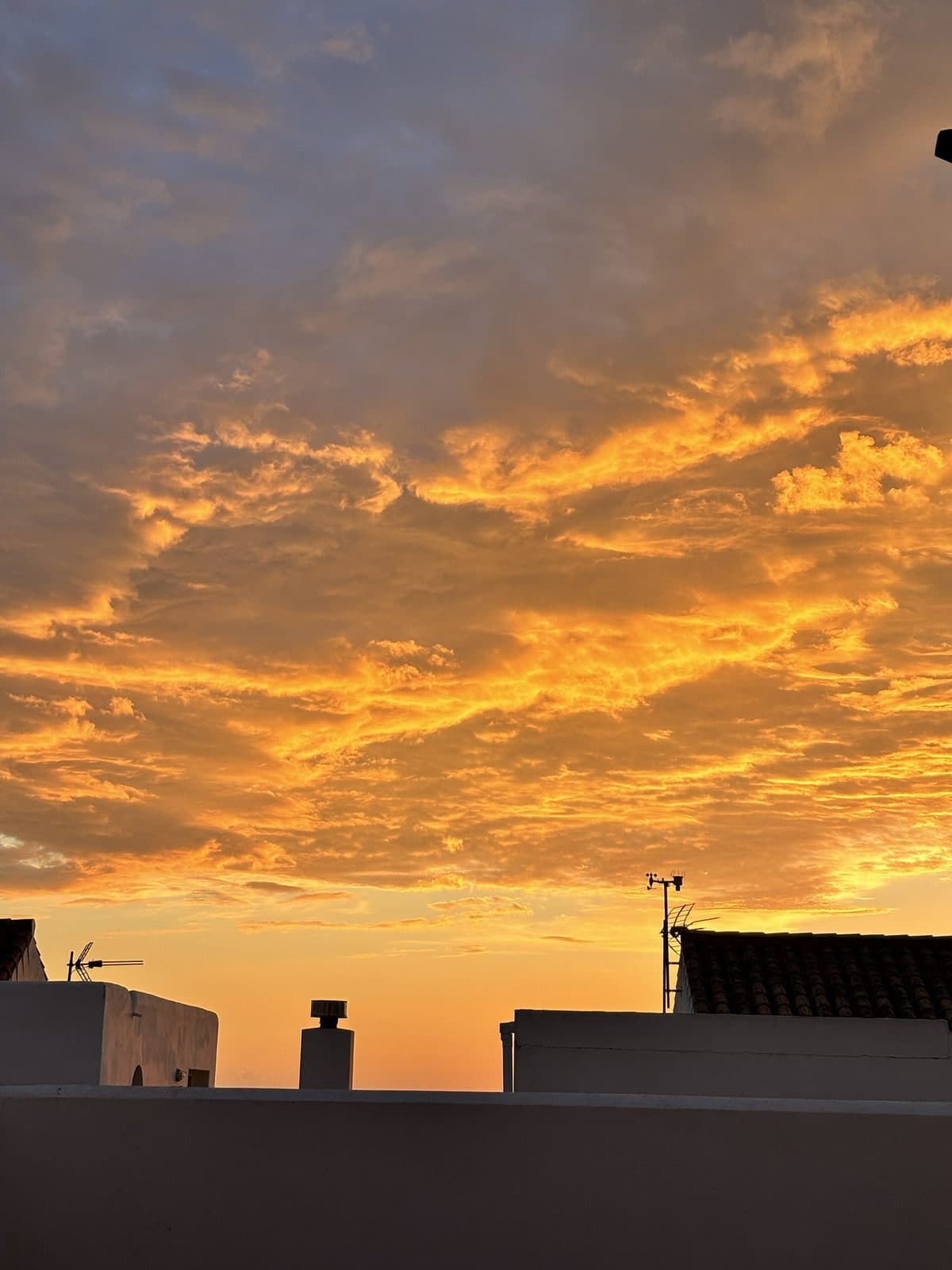 Orange leuchtender Abendhimmel über den Dächern von Tarifa