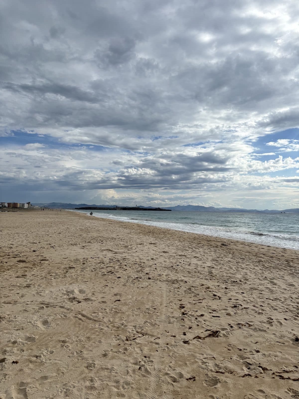 Breiter Sandstrand mit Blick auf die Isla de Tarifa und die Berge Marokkos
