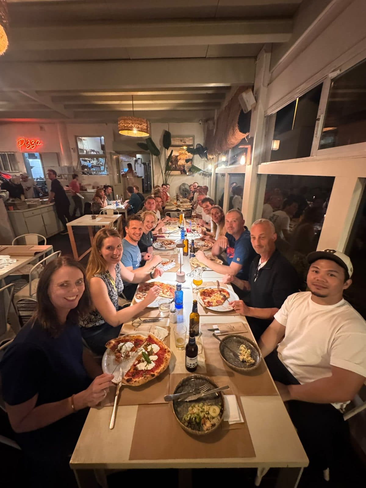 Die Gruppe an einer langen Tafel in einer Pizzeria